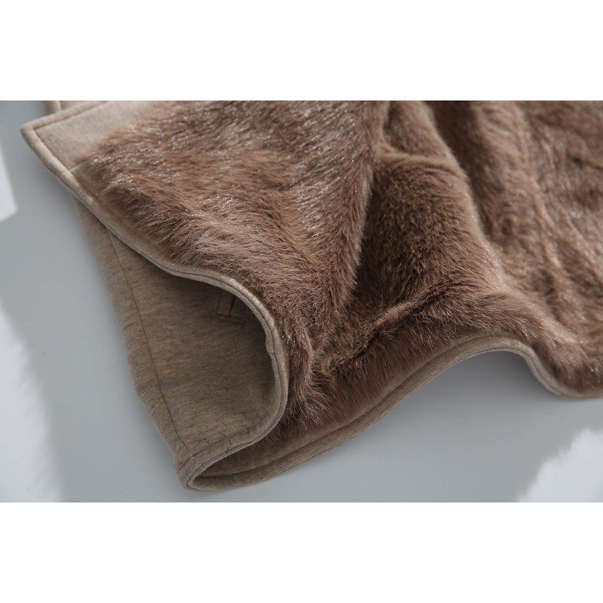 Close-up showing the brown plush lining and beige edging inside a vest.