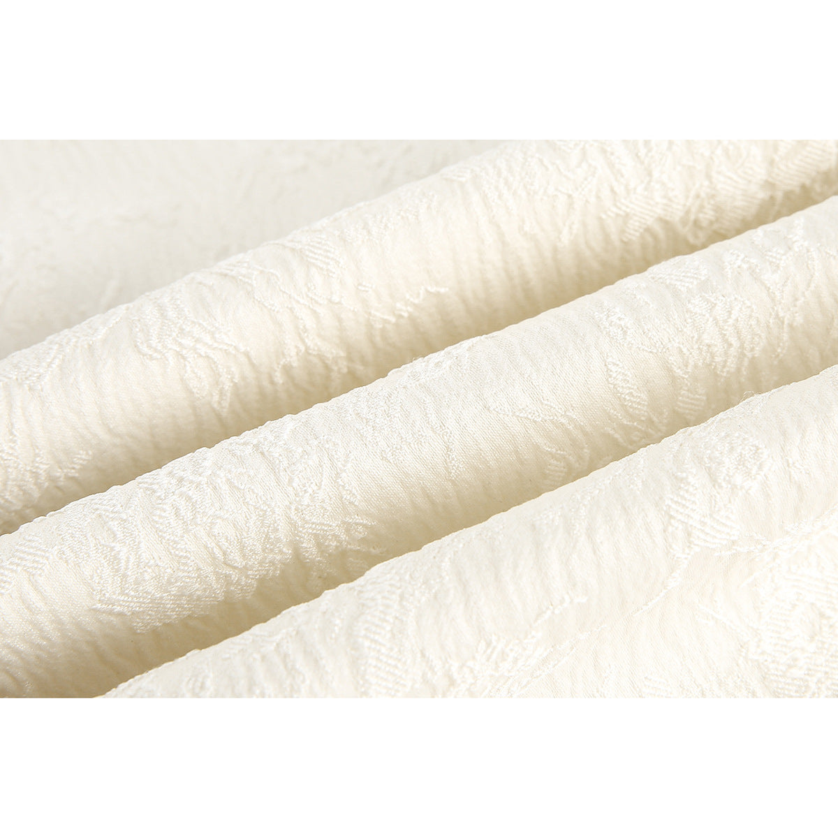 Close-up of the raised woven floral pattern on ivory jacket fabric.
