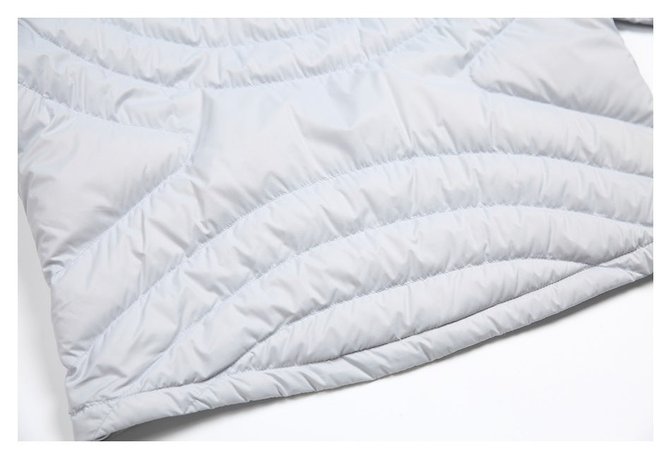 Close-up of the pale gray jacket's curved quilted panels and stitched hem.