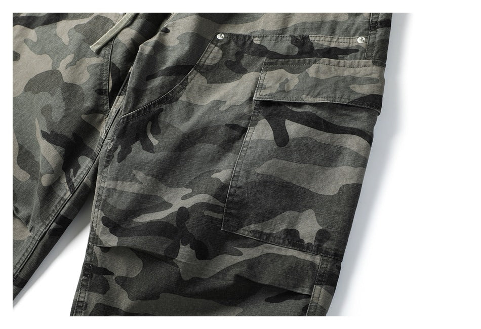 Close-up of a large flap cargo pocket on gray and black camouflage pants.