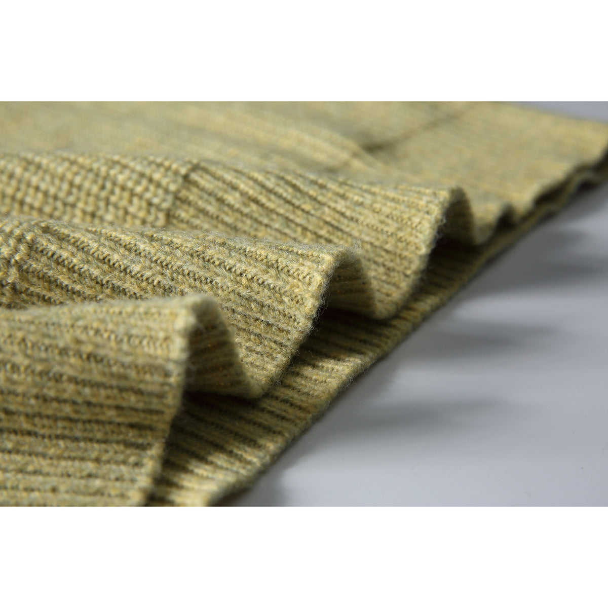 Close-up of the muted olive sweater's ribbed knit and folded edge.