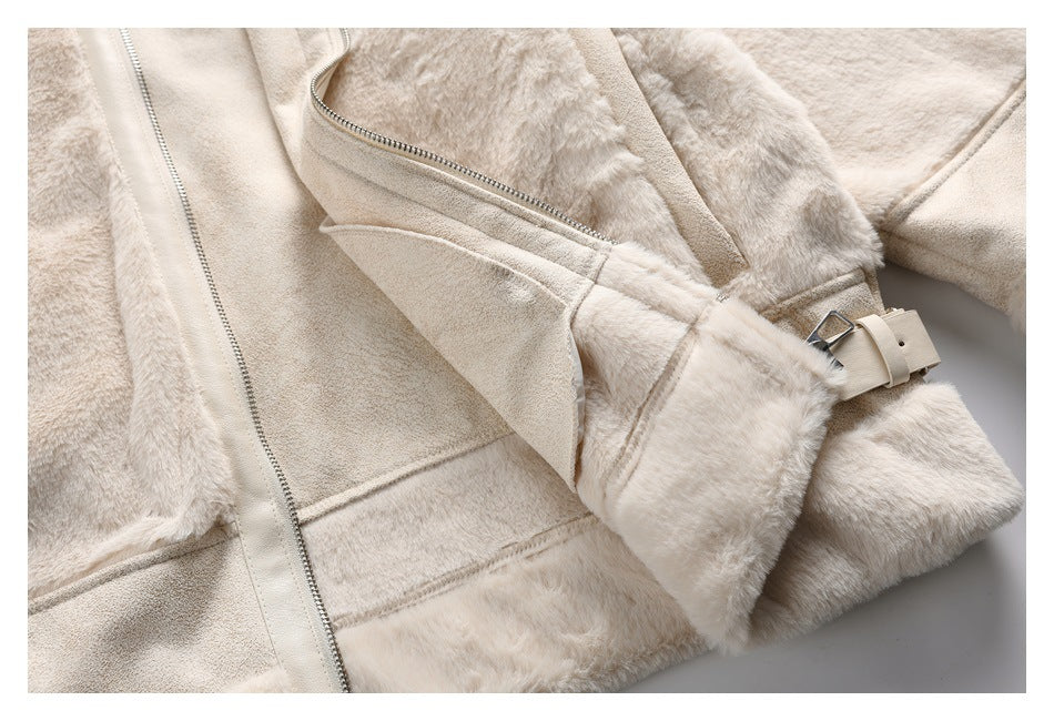Close-up of a cream faux-fur coat showing its zipper, lapel, and adjustable sleeve buckle.