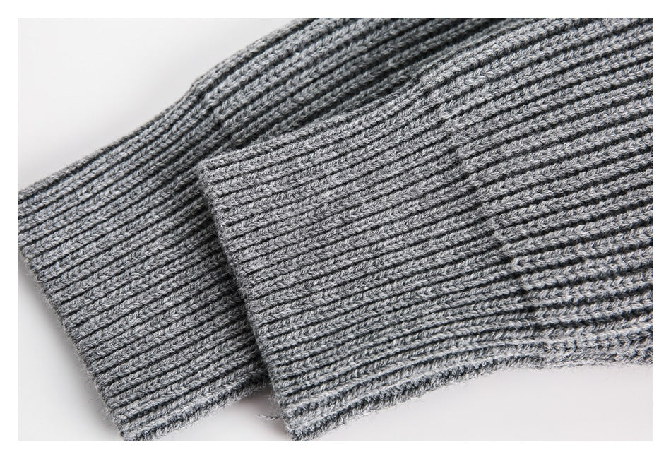 Close-up of the gray rib-knit sweater's folded cuff and sleeve.