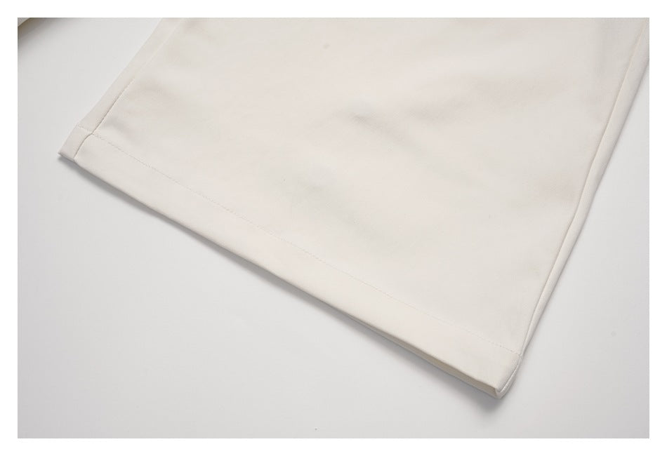 Close-up of the cream garment's stitched hem and edge.
