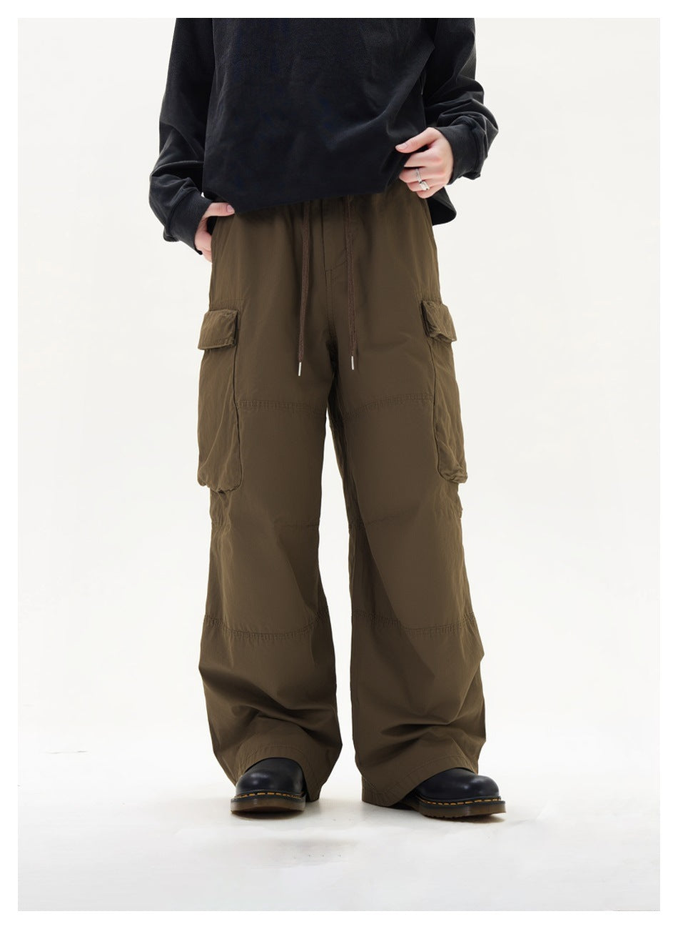 Person wearing brown wide-leg cargo pants with drawstring waist and flap pockets, black top and black boots