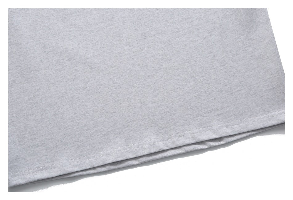 Close-up of the hem and double stitching on a light gray heathered garment.