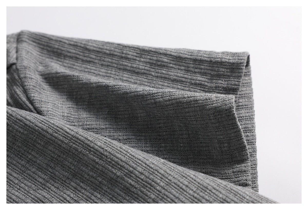 Close-up of folded gray ribbed knit fabric showing a stitched edge.