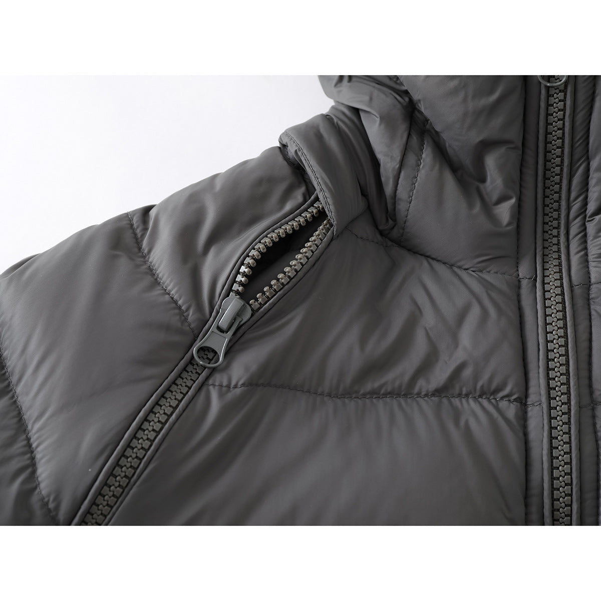 Close-up of a charcoal-gray padded jacket sleeve with an open zipper vent beside the front zipper.