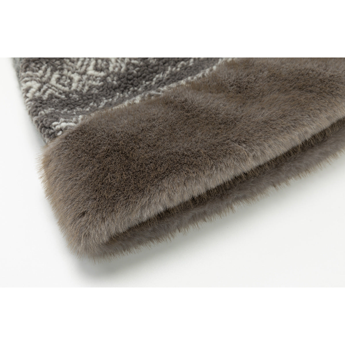 Close-up of a soft, brown-gray furry trim beside a patterned section of the garment.