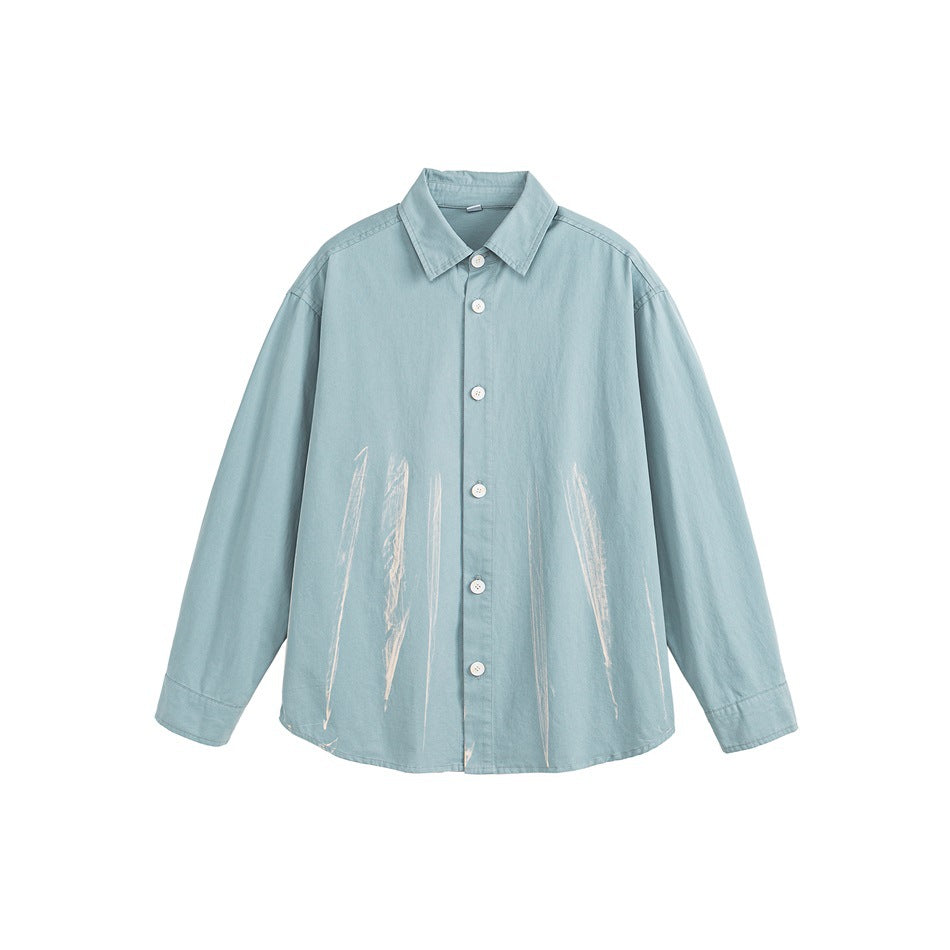 Light blue long-sleeve button-up shirt with cream brushstroke marks on the lower front, flat lay