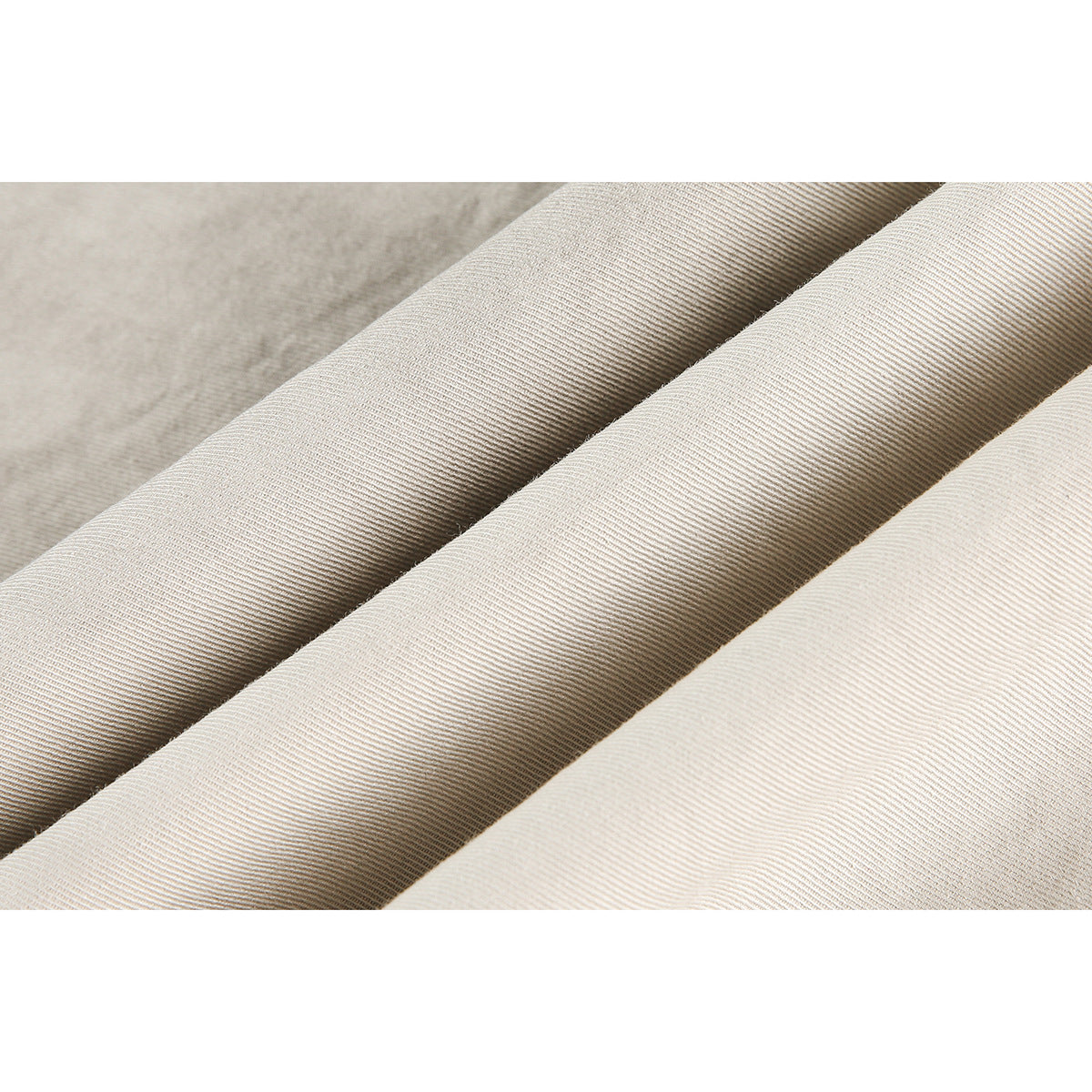 Close-up showing the diagonal weave and folds of light beige shirt fabric.