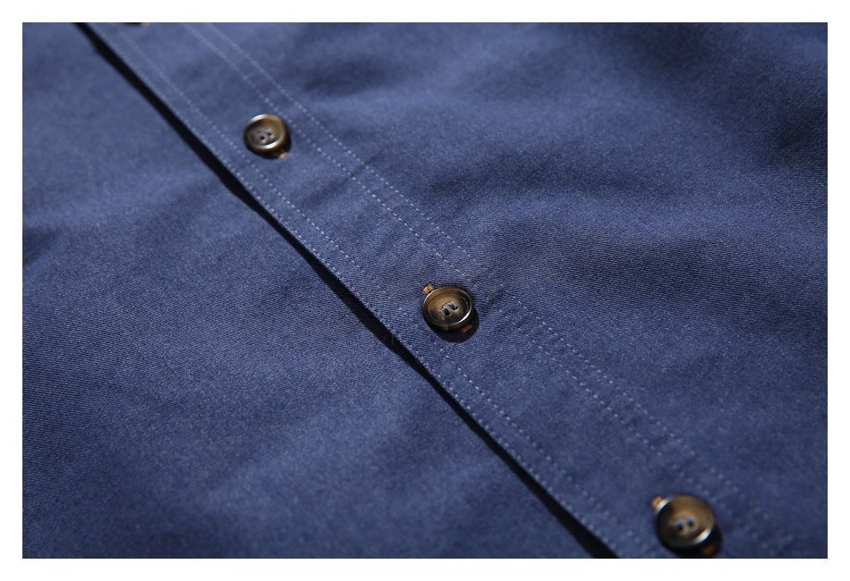 Close-up of a dark navy garment placket with brown buttons and double rows of stitching.
