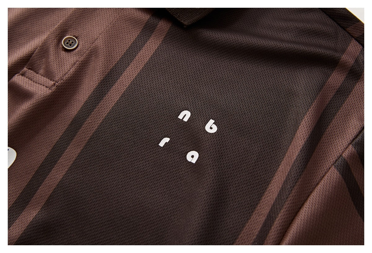 Close-up of small white lettering on the dark brown striped polo shirt.