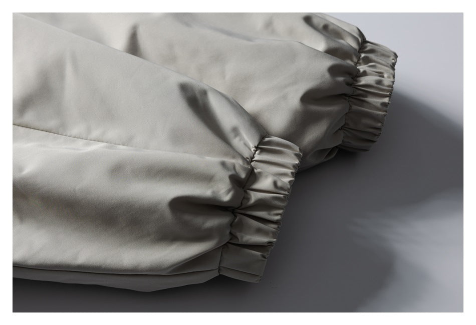 Close-up of a light gray jacket sleeve ending in a gathered elastic cuff.