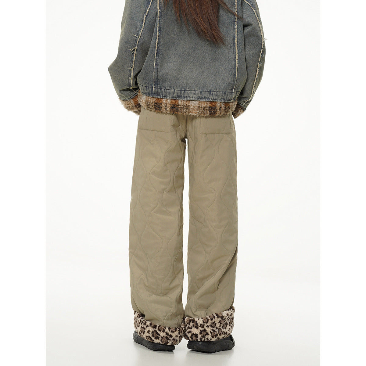 Rear view of a model wearing khaki quilted wide-leg pants with brown patterned fleece cuffs.