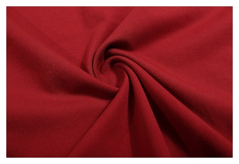 Close-up of deep red knit fabric gathered into soft folds, showing its fine ribbed texture.