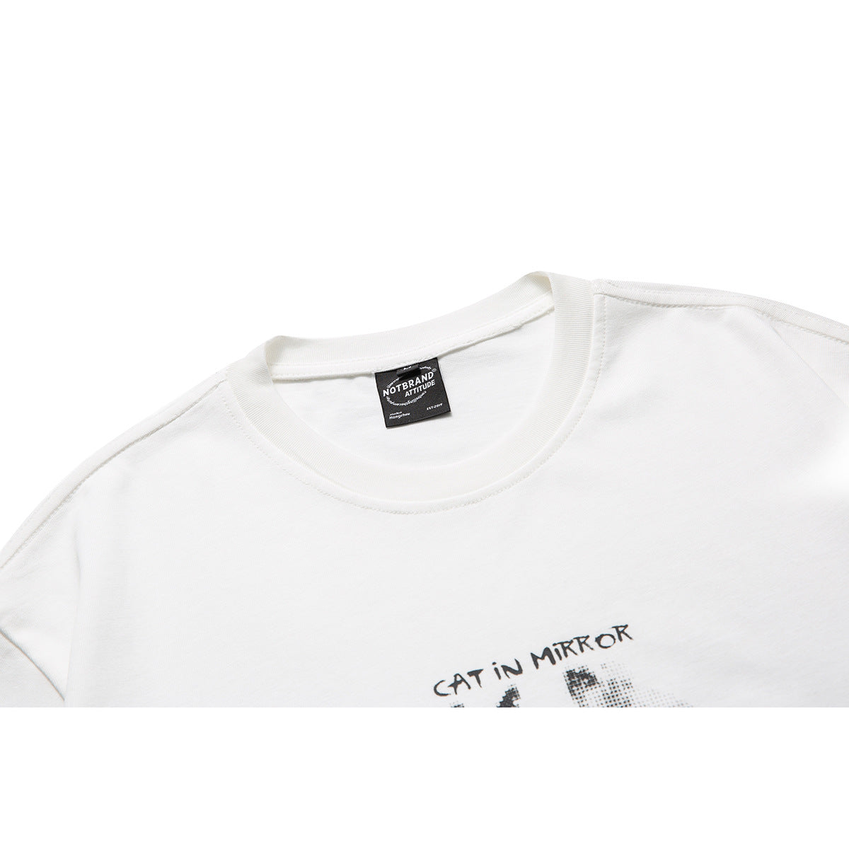 Close-up of a white crew-neck T-shirt with part of a black graphic print visible on the chest.