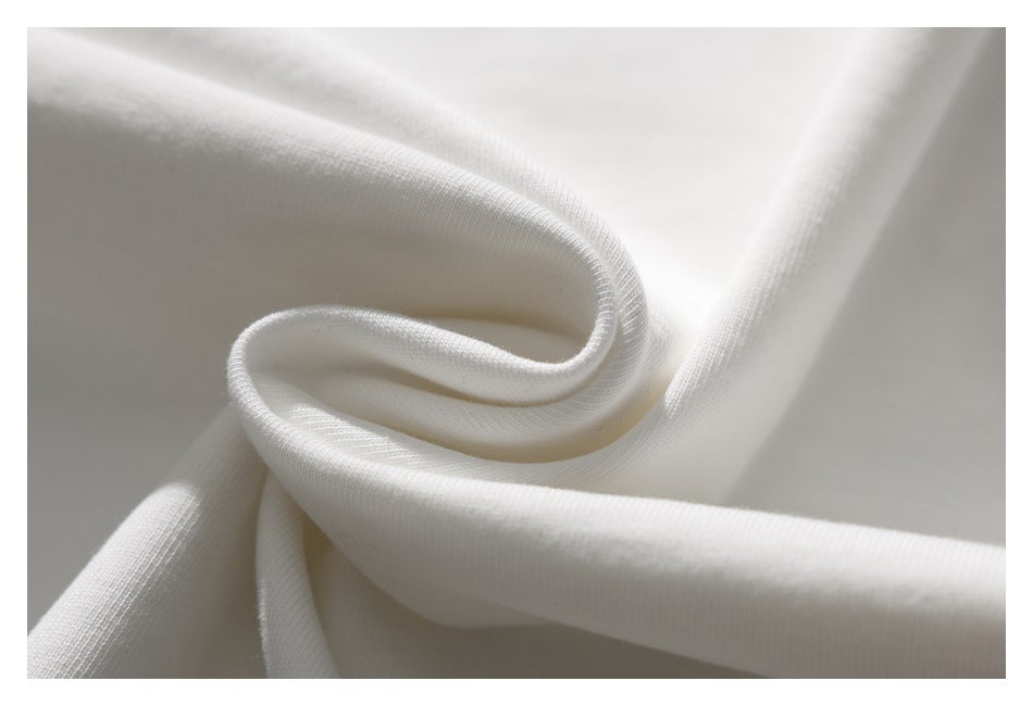 Close-up of white fabric twisted into a soft fold, showing its texture and drape.