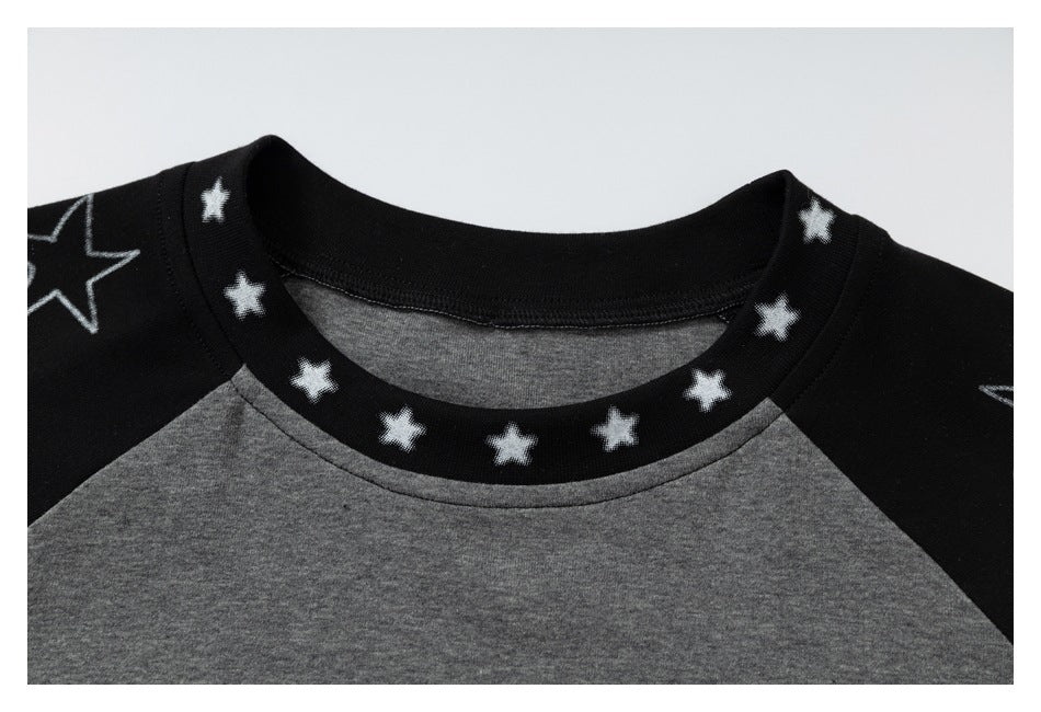 Close-up of the gray T-shirt's black crew neck and raglan shoulder seams, with white stars on the trim and sleeves.