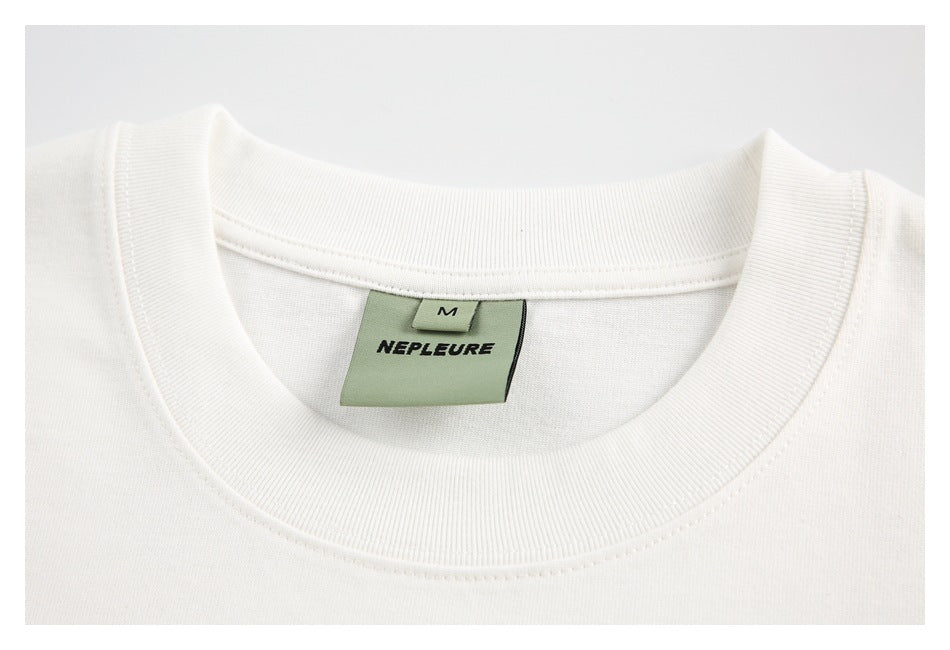 Close-up of a white crewneck collar with a sewn-in size M brand label.