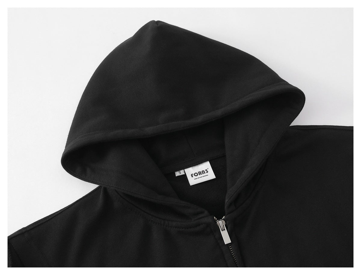 Close-up of a black sleeveless hoodie’s hood, silver zipper, and inner neck label.