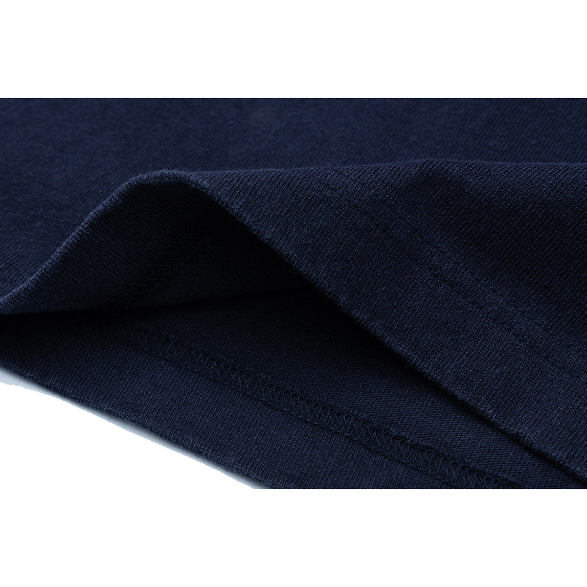 Close-up of dark navy shirt fabric folded to show the hem and stitching.