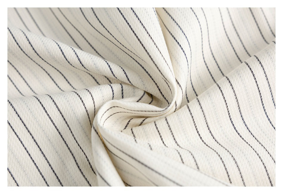 Close-up of cream striped fabric gathered to show its folds and texture.