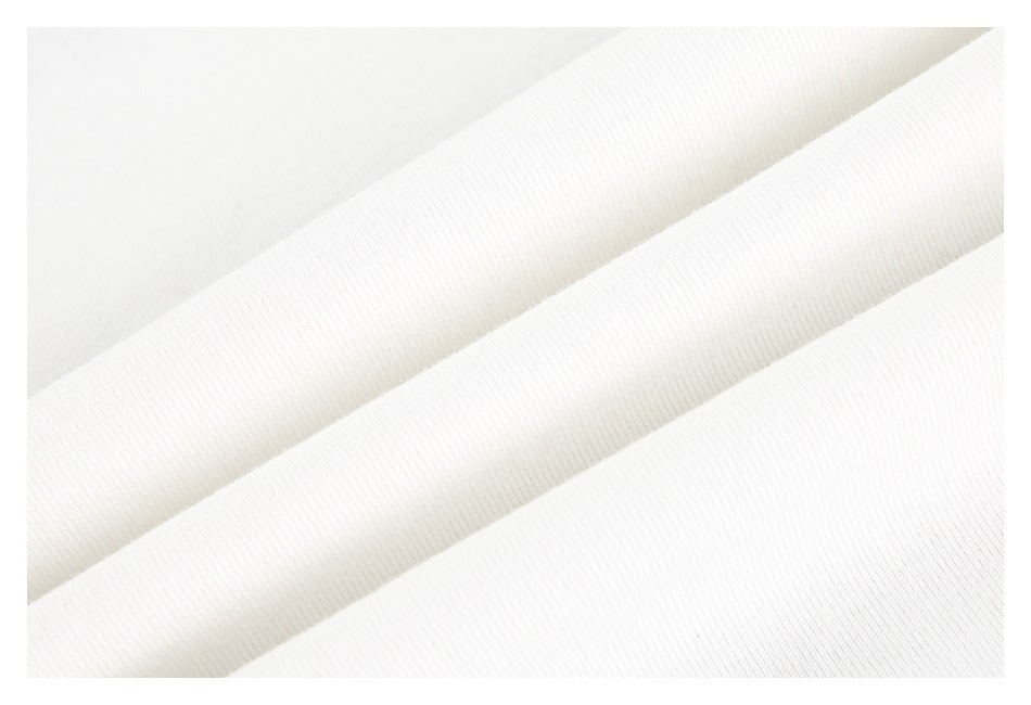 Close-up of white ribbed knit fabric arranged in overlapping diagonal folds.