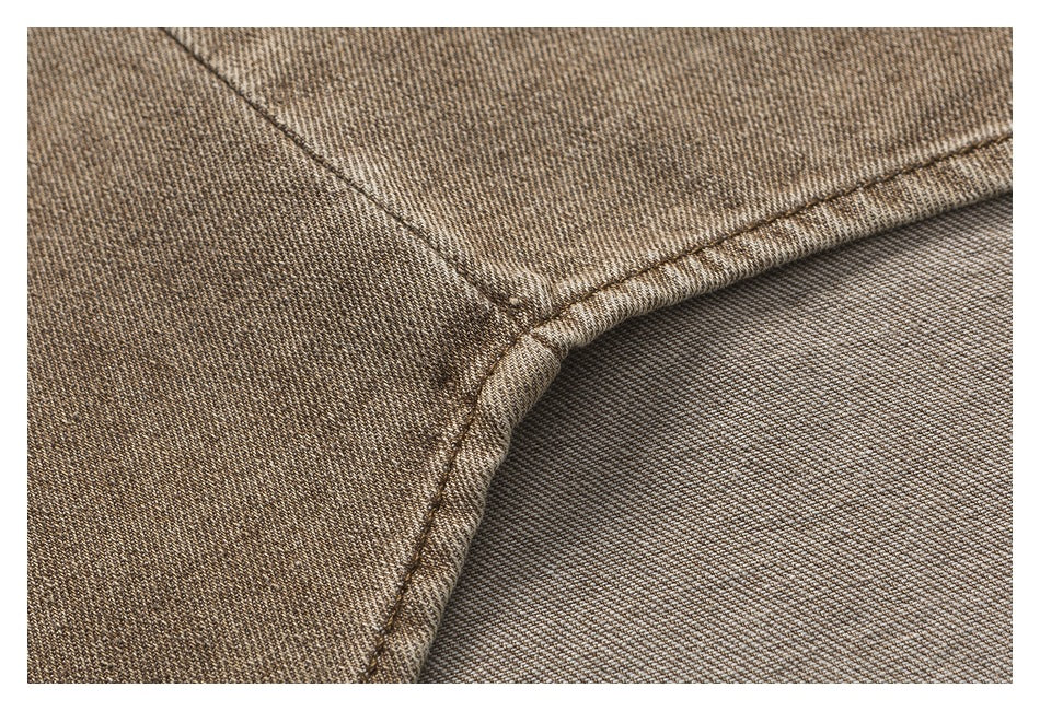 Close-up of a curved seam and folded edge on brown twill fabric.