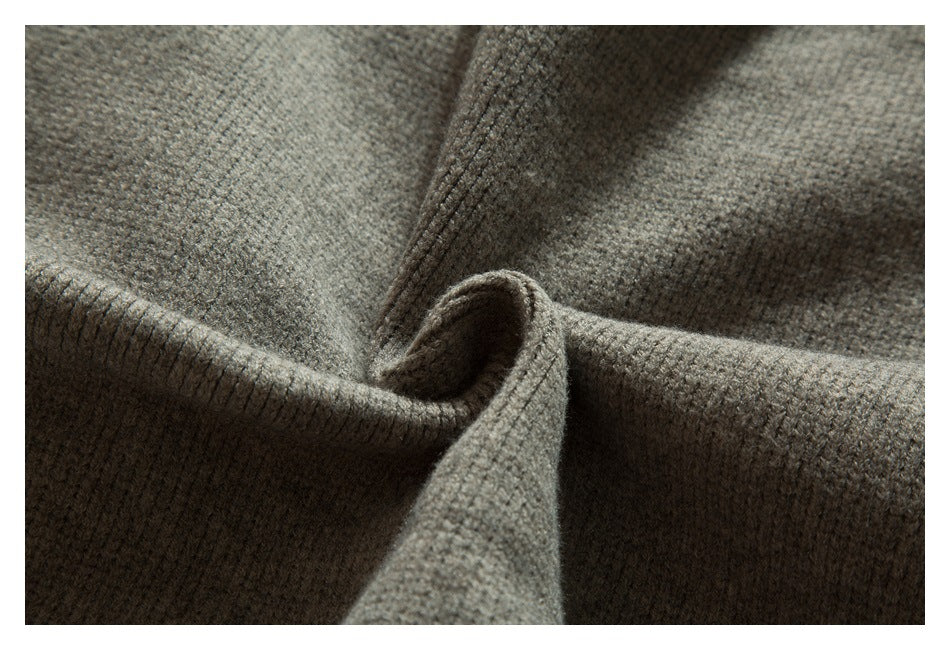Close-up of taupe-gray knit fabric folded and draped to show its texture and thickness.