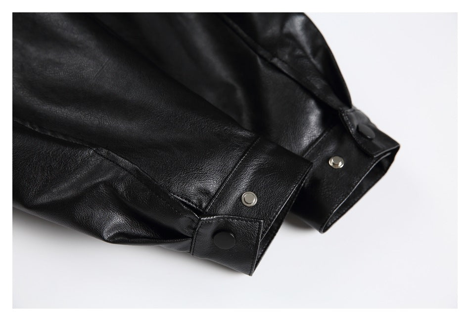 Close-up of black jacket cuffs with snap-button tabs and metal snaps.