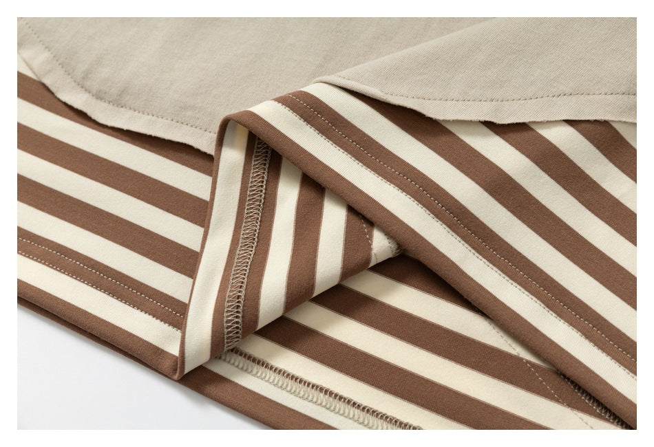 Close-up of brown-and-cream striped fabric folded to show its overlocked seam beneath a beige T-shirt.