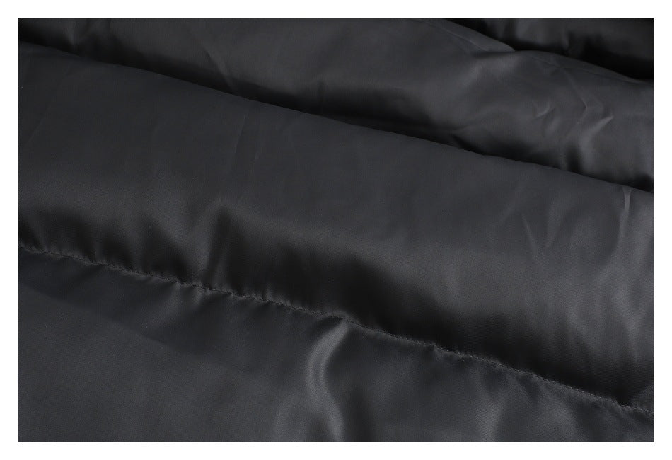 Close-up of black garment fabric showing a long stitched seam and subtle surface texture.