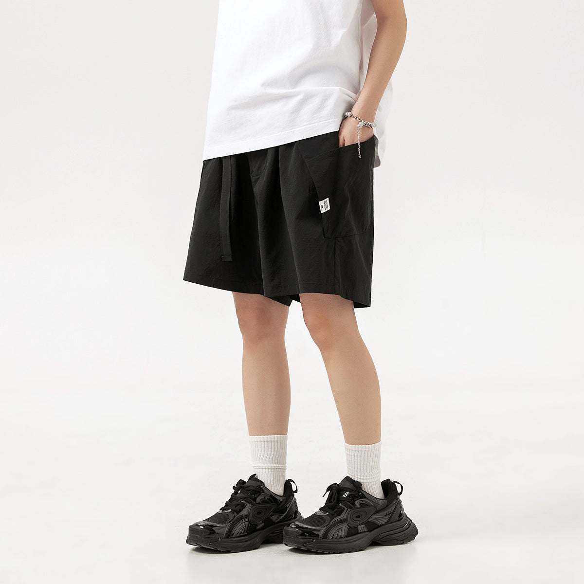 Model wearing black knee-length shorts with a drawstring waist and side pocket.