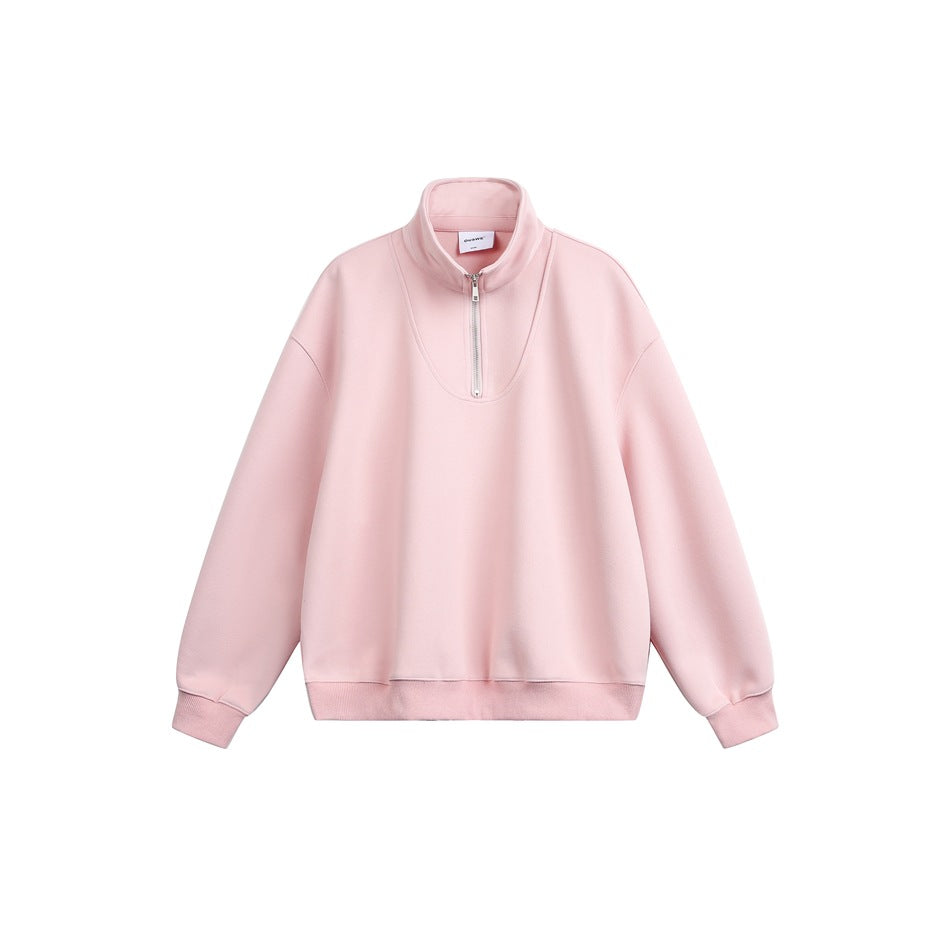 Front view of a pale pink pullover with a high collar, short front zipper, dropped shoulders, and ribbed cuffs and hem.