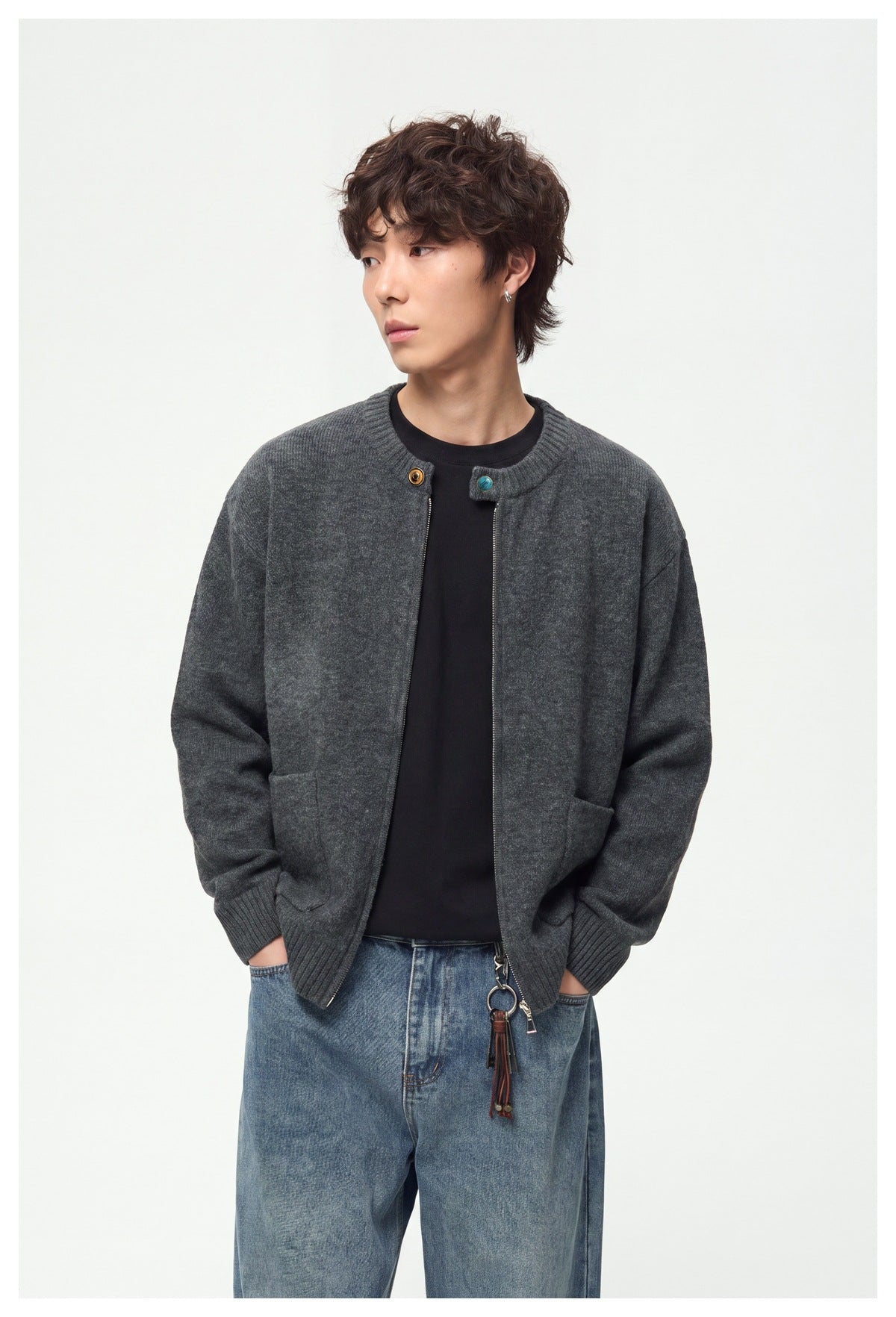 Model wearing a charcoal gray zip-front cardigan with ribbed trim and patch pockets over a black shirt.