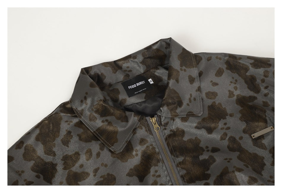 Close-up of a gray-brown spotted jacket showing its pointed collar, front zipper, and sewn-in neck label.