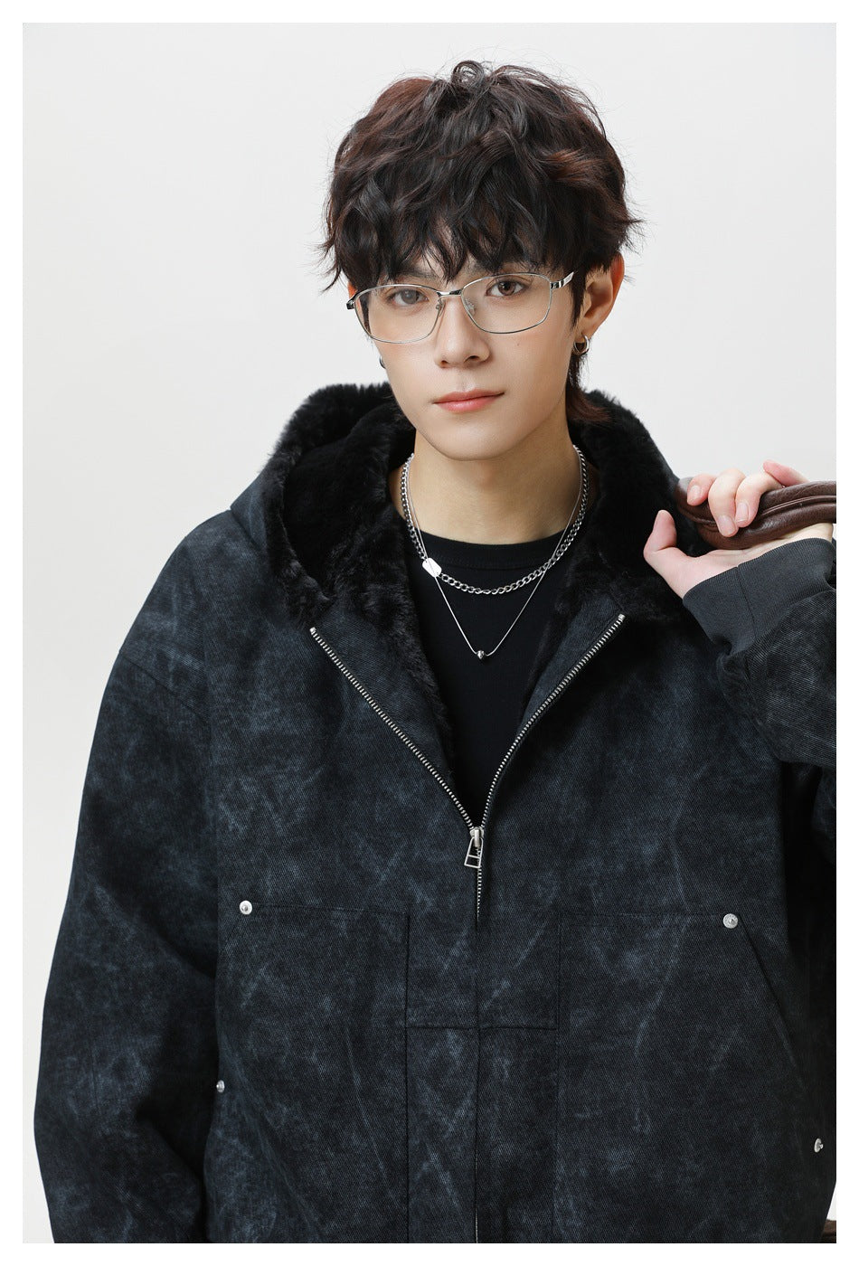 Close view of a model wearing a charcoal mottled hooded jacket with black plush lining and silver zipper.