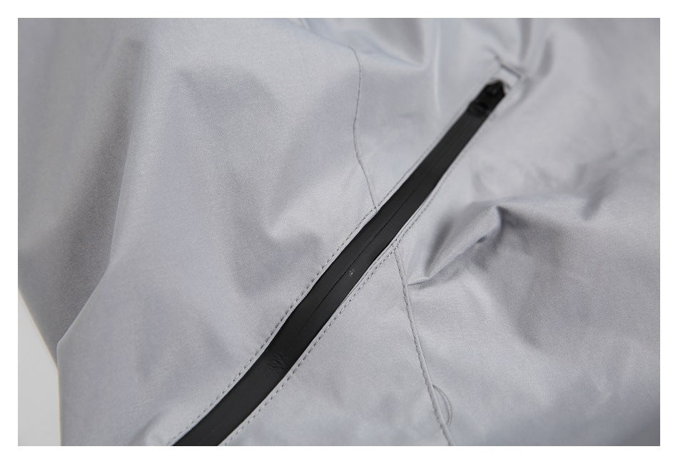 Close-up of a long black zipper pocket on light gray trousers.