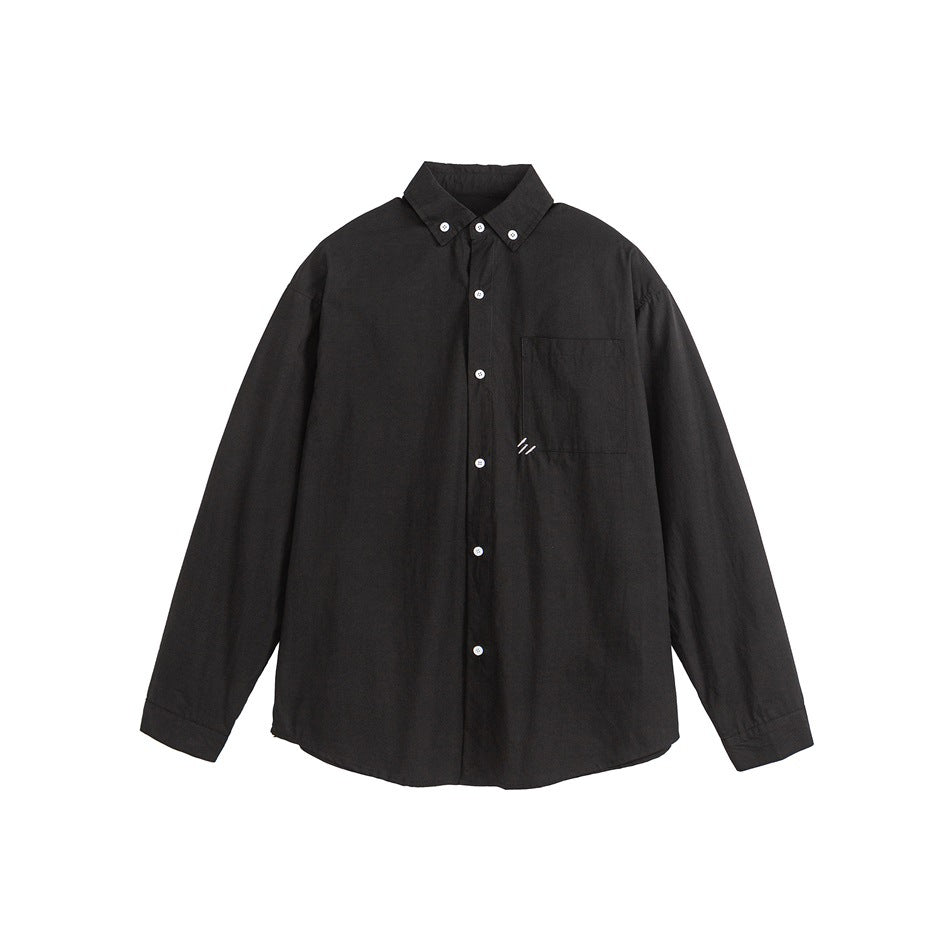 Black long-sleeve button-down shirt flat lay with chest pocket and small white stitched slash mark