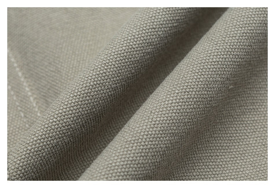 Close-up showing the coarse woven texture and folds of beige jacket fabric.