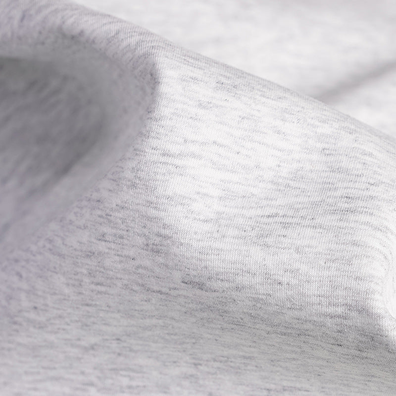 Extreme close-up of light gray fabric with subtle darker heathering.