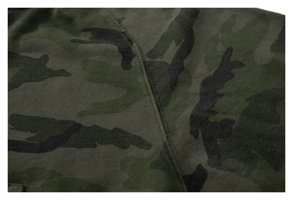 Close-up of a stitched seam across the olive, gray, and black camouflage hoodie fabric.