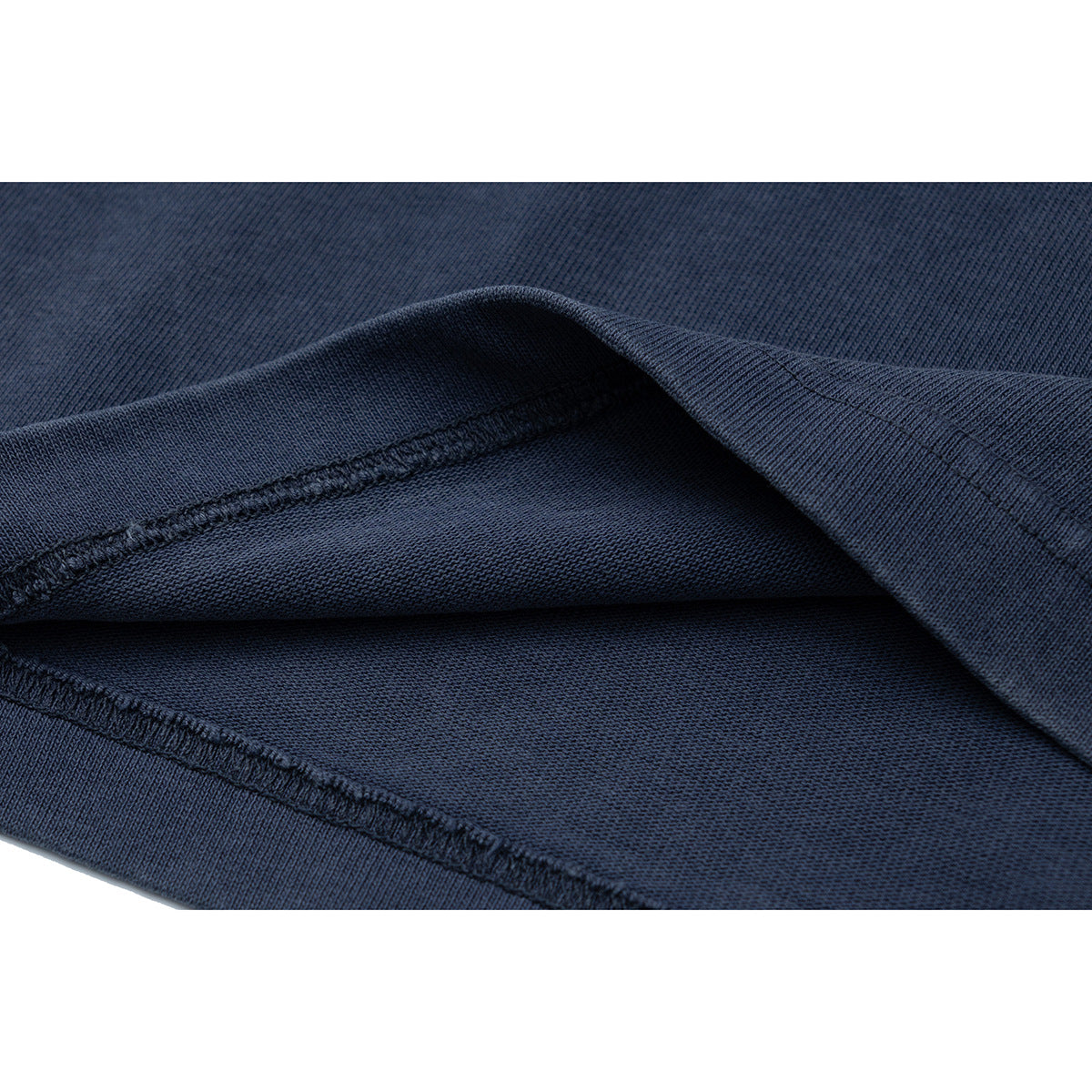 Close-up of the dark navy shirt's folded fabric edge and visible stitching.