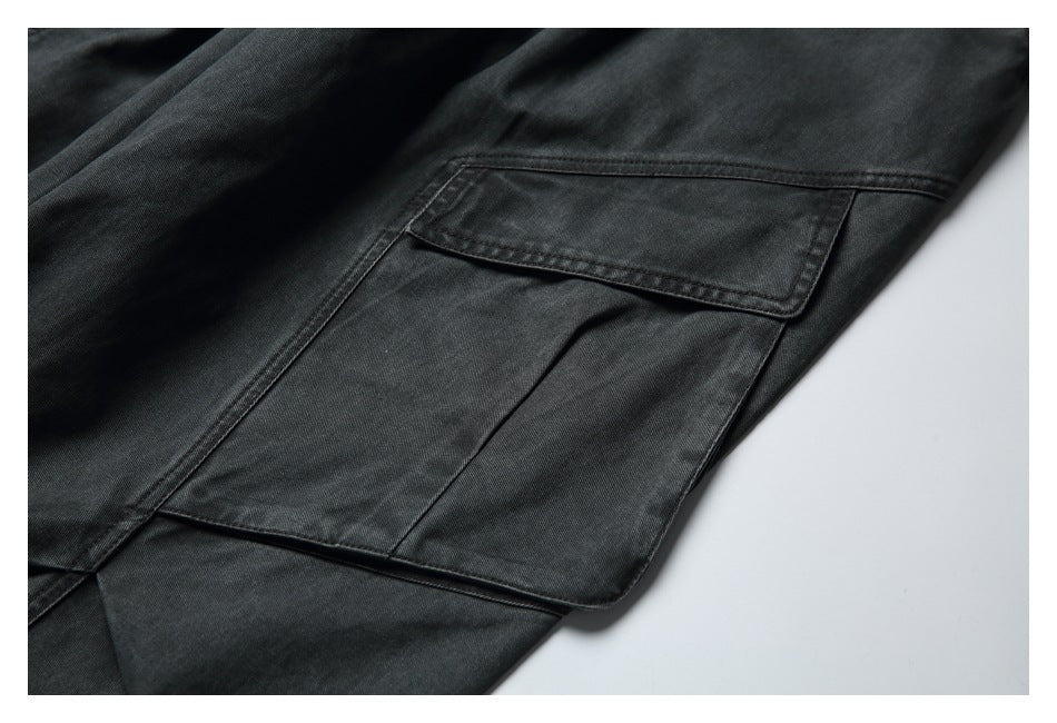 Close-up of a large flap cargo pocket on charcoal pants.