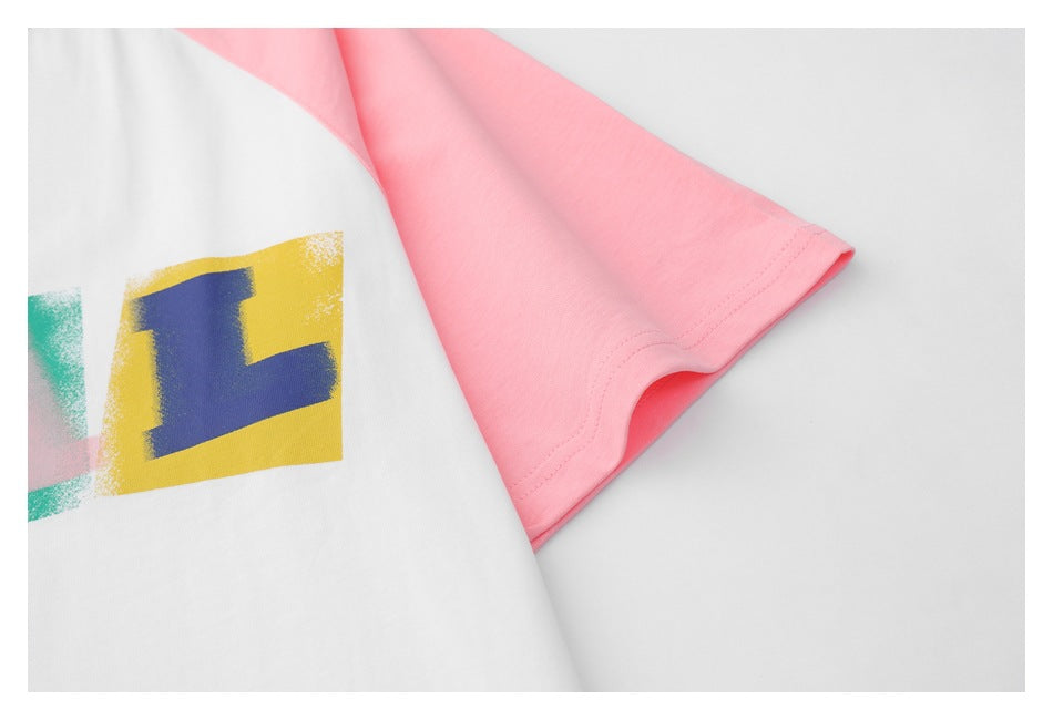 Close-up of a pink short sleeve beside the cropped colorful print on a white T-shirt.