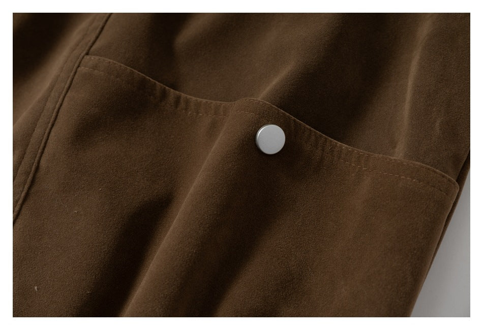 Close-up of a brown garment pocket with a light-colored snap button.
