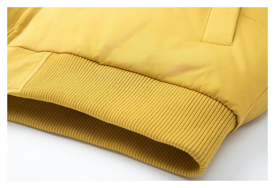 Close-up of the mustard-yellow jacket's wide ribbed hem and lower pocket area.