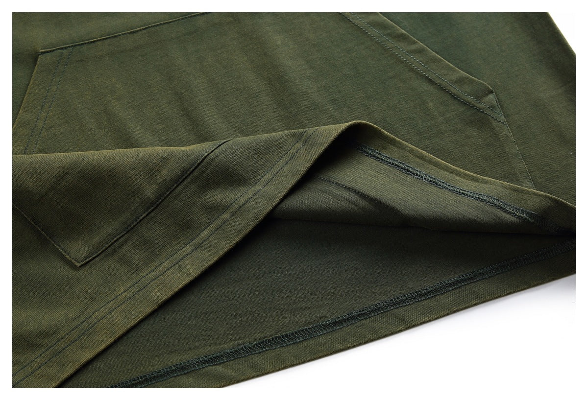 Close-up of an olive green garment showing a pocket, stitched seams, and a turned hem.