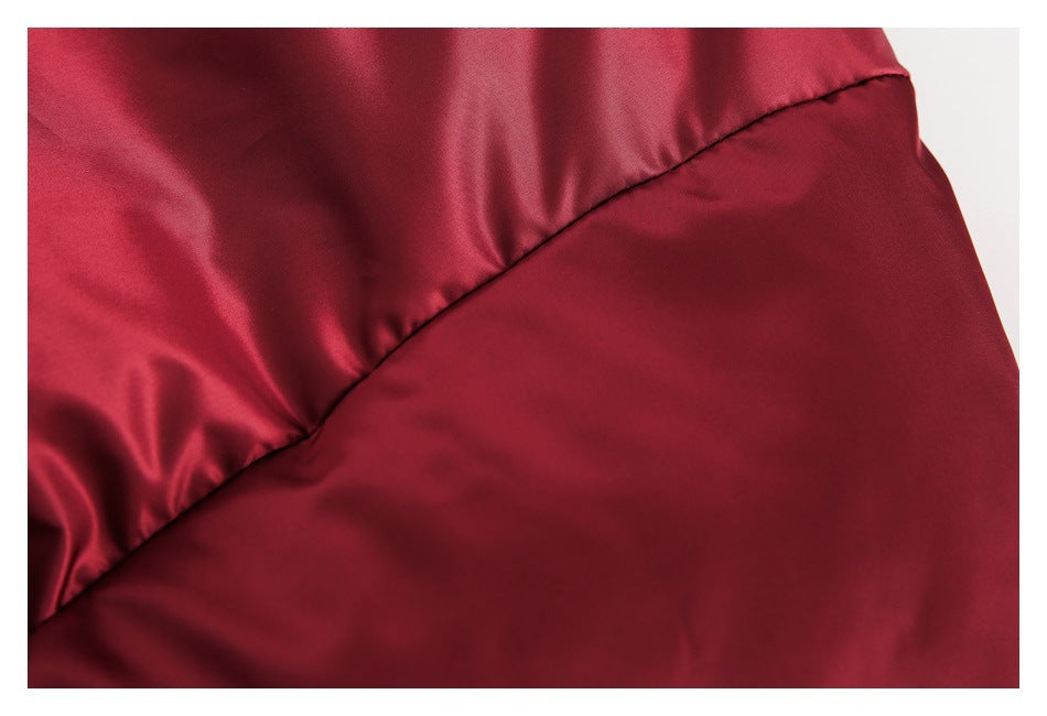 Close-up of a curved stitched seam joining two burgundy jacket panels.